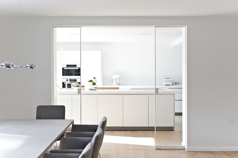 Küche und Esszimmer unterteil durch Doppelschiebetür mit weißem Rahmen und klarem Glas