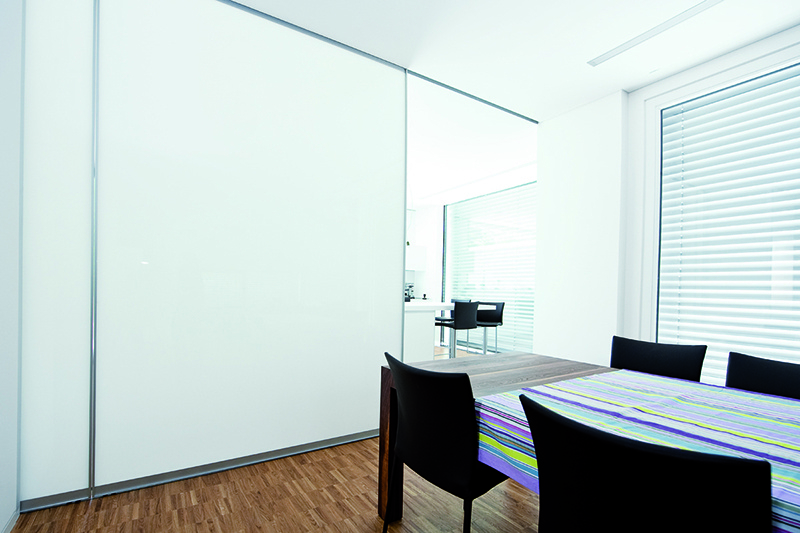 Küche und Esszimmer unterteilt durch große Schiebetüren aus weißem Glas