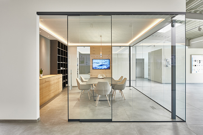 Bürogebäude mit Besprechungsraum abgetrennt durch Raumteiler Schiebetüren mit Klarglas