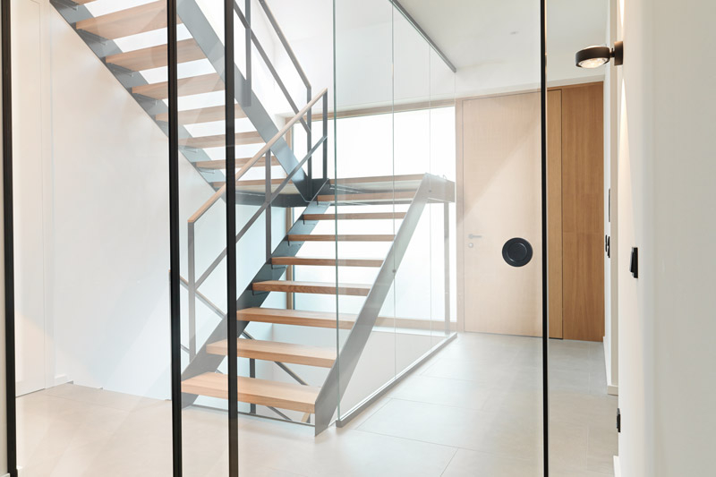 Treppenhaus und Eingangsbereich unterteilt durch Loft Schiebetüren aus klarem Glas