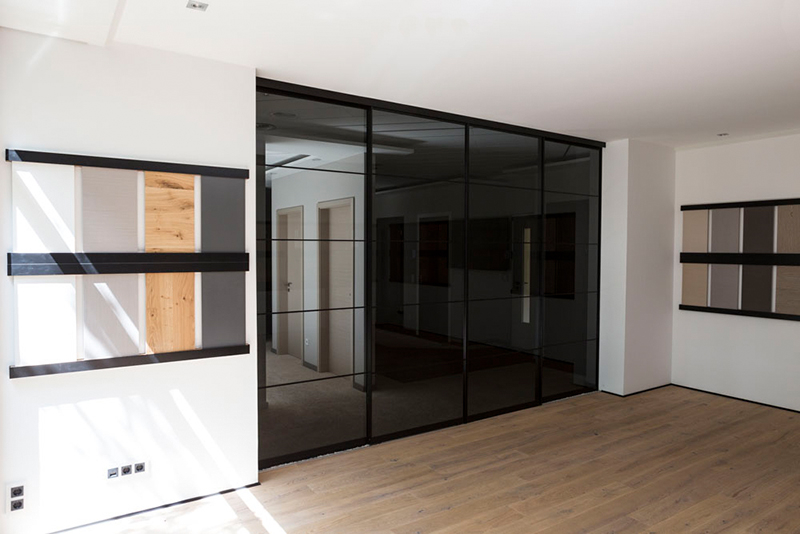 Büro und Besprechungsraum unterteilt durch Loft Schiebetüren aus getöntem Glas