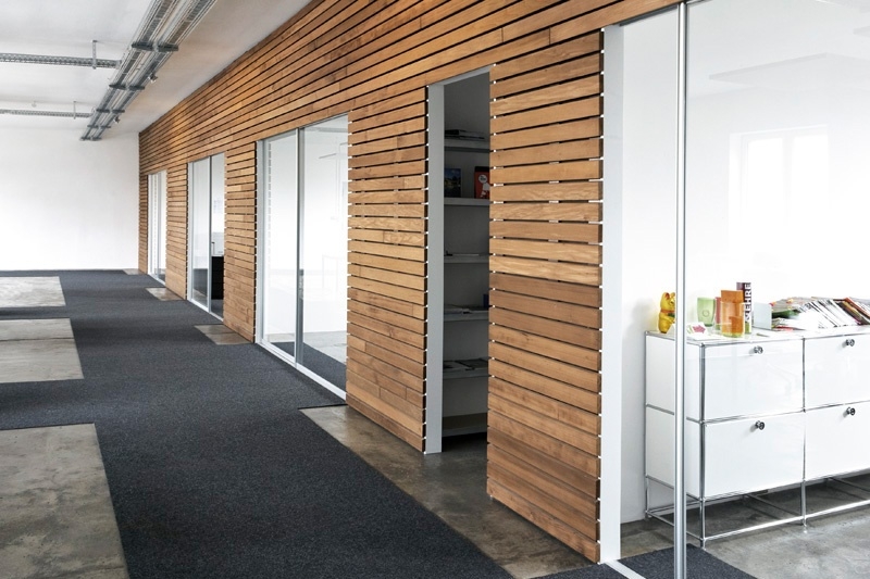 Großraumbüro mit Besprechungsräumen unterteil durch Schiebetüren aus klarem Glas