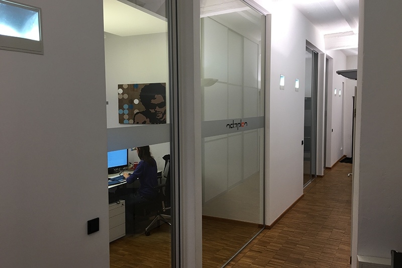 Bürofläche und Einzelbüros abgetrennt durch Schiebetüren mit Schallschutzglas