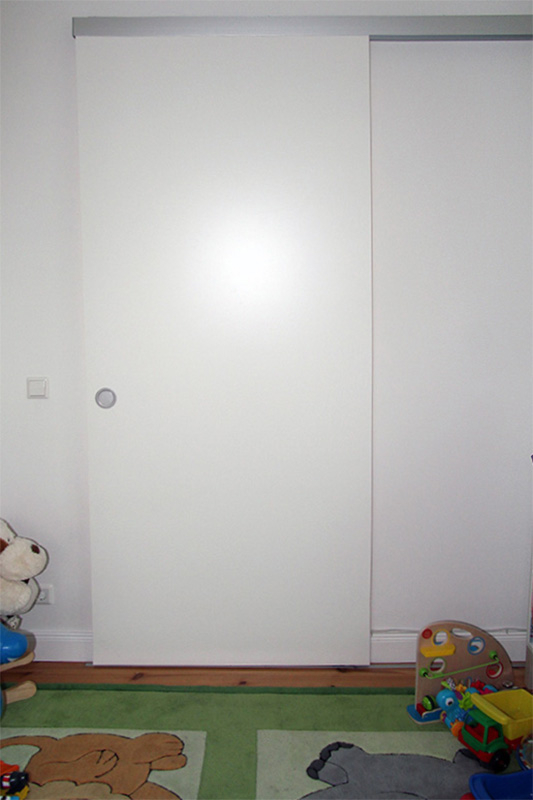 Flur und Kinderzimmer unterteilt durch weiße Holzzschiebetür