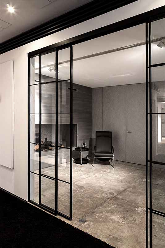 Wohnraum unterteilt durch Loft Schiebetüren mit schwarzem Rahmenprofil Sprossen un klarem Glas